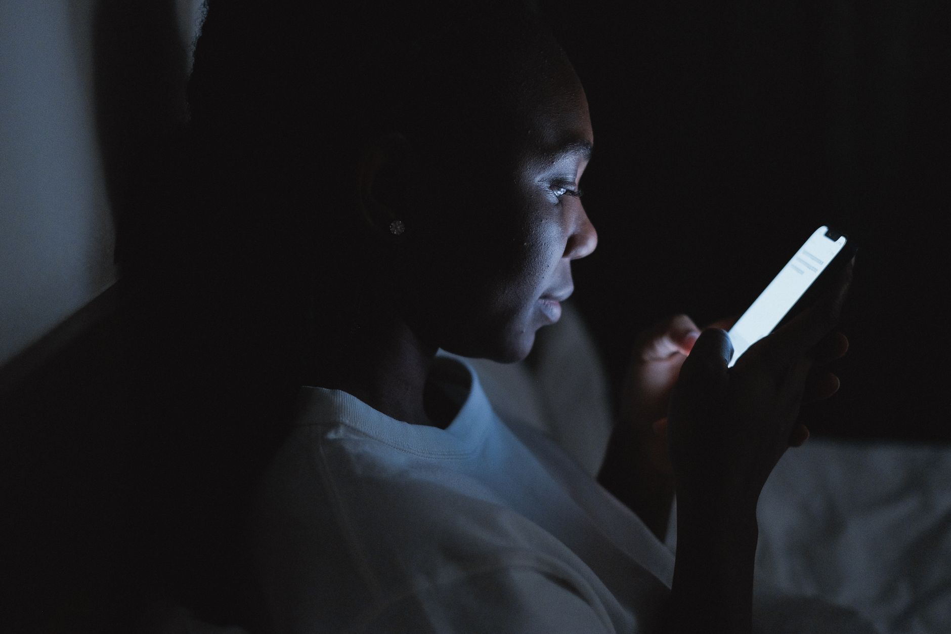 夜遅くにスマートフォンを見る女性のイメージ