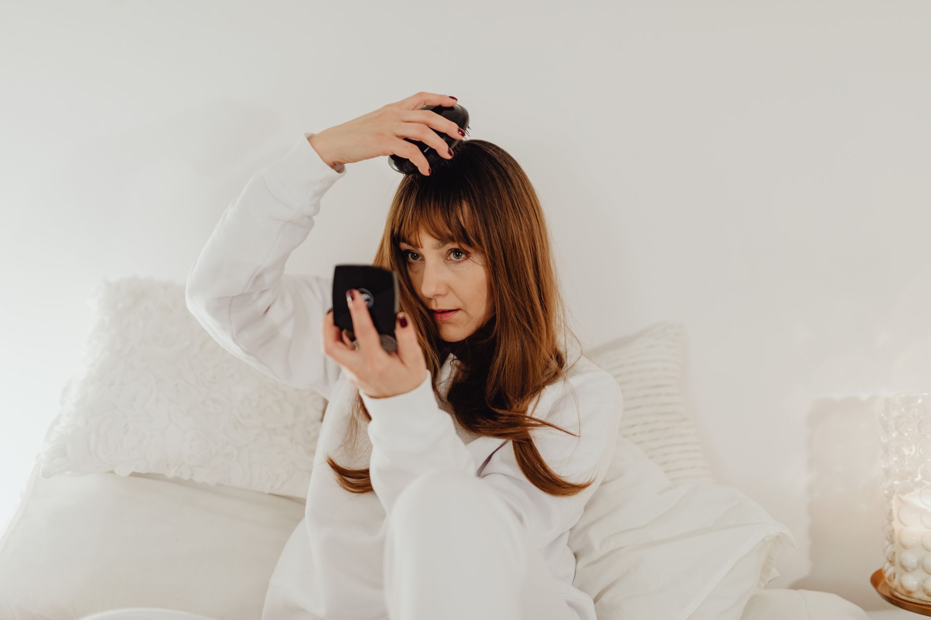 鏡の前で髪をとかす女性のイメージ