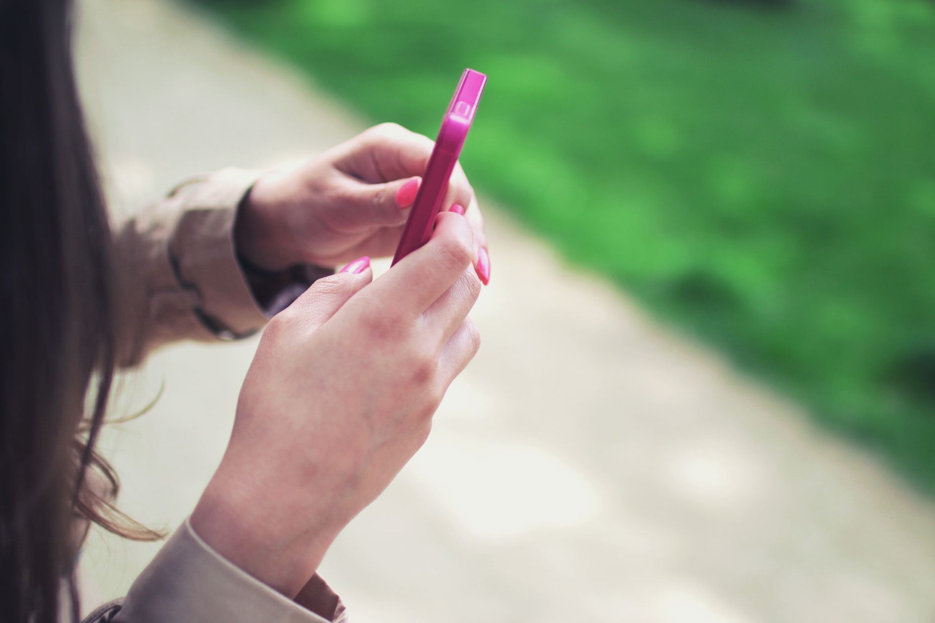 スマートフォンでメッセージを送っている女性のイメージ